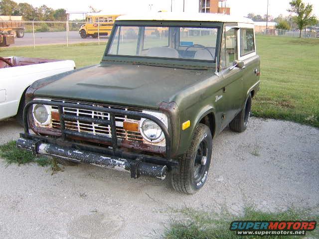 Green 1976 Ford Bronco with a white roof and black grille