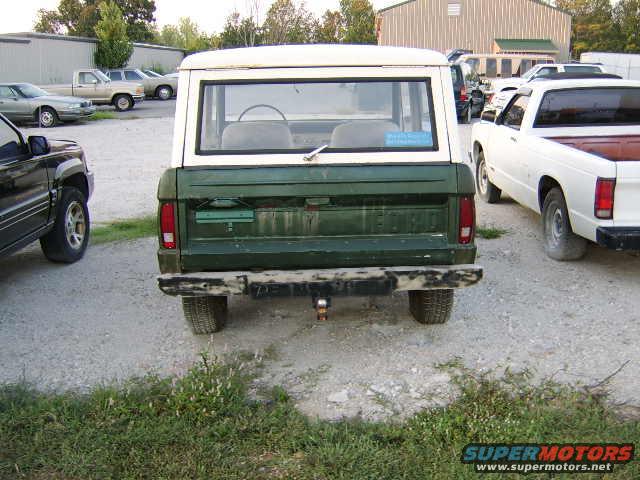 1976 Ford Bronco rear view, parked next to a white pickup truck