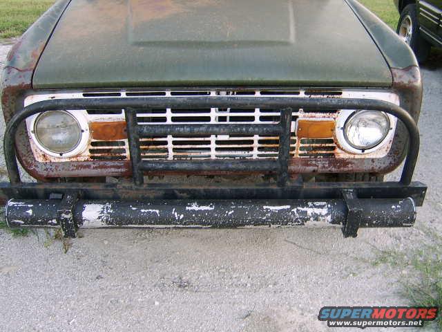 1976 Ford Bronco front end with a brush guard and rusty bumper