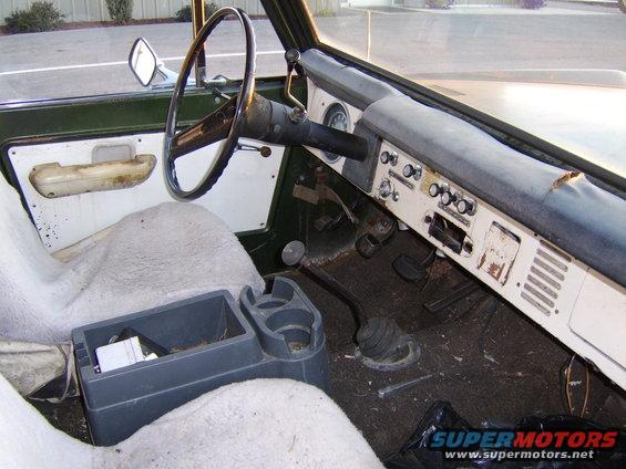Interior of a 1976 Ford Bronco showing dashboard, steering wheel, and seats