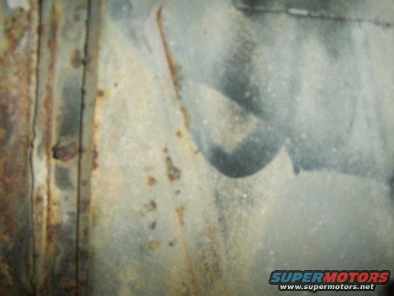 close-up of a rusty metal panel with some gray paint