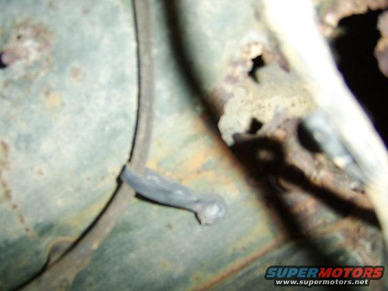 Close-up of rusted metal with a black wire and clip, showing signs of corrosion