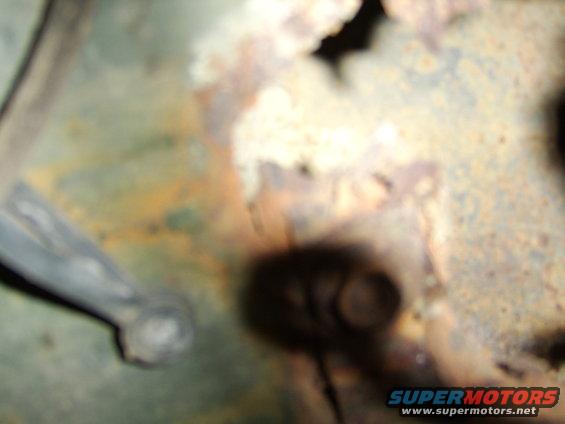 Rusted metal surface with a dark shadow obscuring details