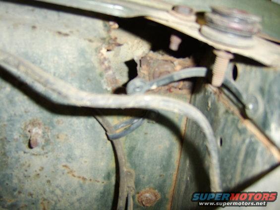 close-up of rusty inner fender well with wires and bolts
