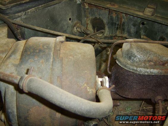 Rusted engine bay with brake master cylinder and other components visible