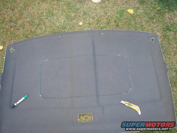 after measure it 99 times i centered the plastic insert ring and taped it down, then drew a line with a felt marker NEATLY.
i cut the hole in the headliner with a carpet knife