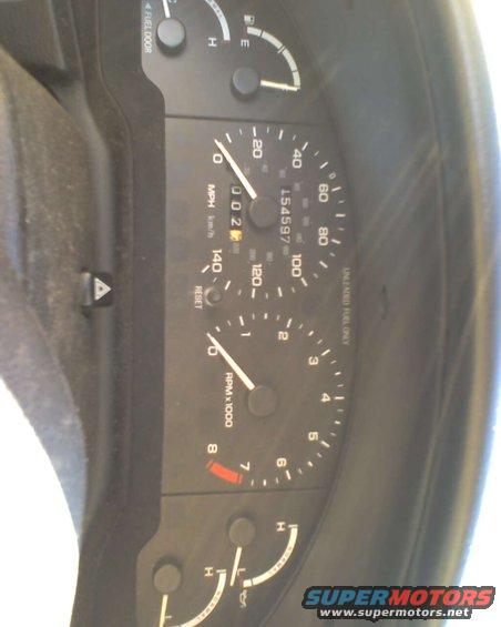 Dashboard gauges with odometer reading 002 and 154597 miles, tachometer, and fuel gauge