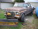 1978 Ford F-250 - This 1978 Ford F-250 truck is equipped with a plow and winch, parked outdoors.