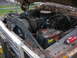 1978 Ford F-250 - The engine bay of an older truck shows a V8 engine, battery, and radiator, covered in debris with a spray can nearby.
