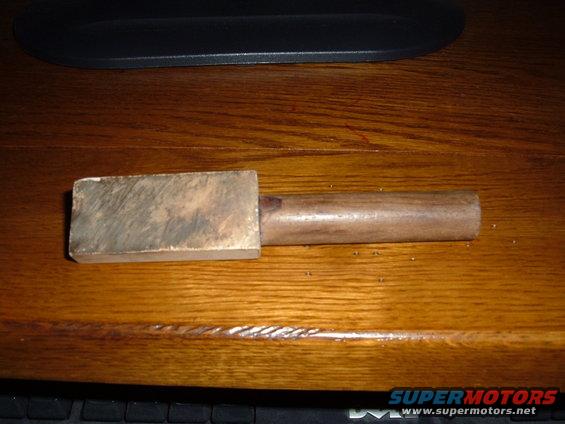 Sharpening stone with wooden handle on a wooden desk