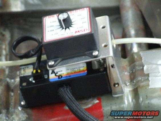 MSD ignition control module with a dial and wiring attached, mounted to a metal bracket