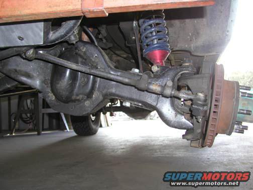 Vehicle's front axle, differential, and suspension components, with a blue coilover shock