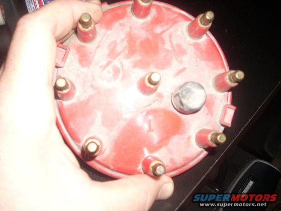 Red distributor cap with brass terminals and a visible number '1'
