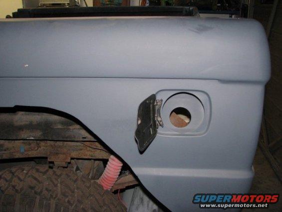 1976 Ford Bronco rear fender with fuel filler door open, showing tire and suspension components
