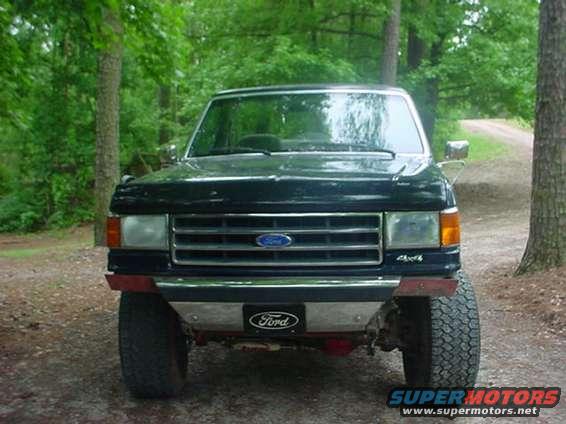 Front view of a black Ford F-Series truck with a chrome grille and a Ford badge on the bumper
