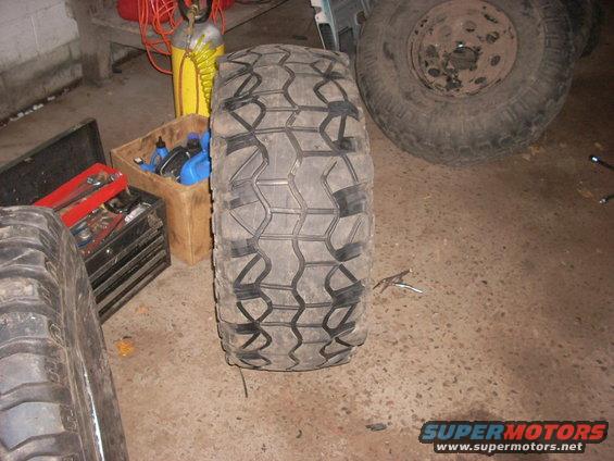 Off-road tire and spare wheel in garage with tools