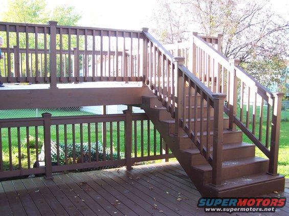 Wooden deck and stairs with brown railings and steps