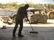 1996 Ford Bronco - A man sweeps the floor in front of a vehicle undergoing restoration, with a loader in the background.