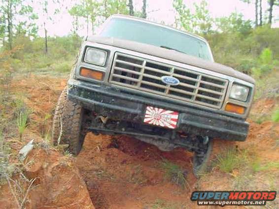 Ford Bronco with a Japanese rising sun sticker on the front bumper, tilted on a dirt hill