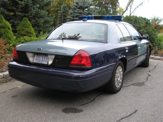 Police car, rear view, dark blue and grey two-tone paint, license plate "STATE POLICE 322"