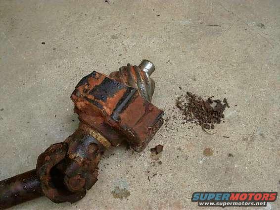 rusted universal joint and driveshaft part on concrete floor