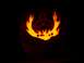 1990 Ford Escort - A carved pumpkin features a triquetra symbol surrounded by flames, illuminated from the inside.