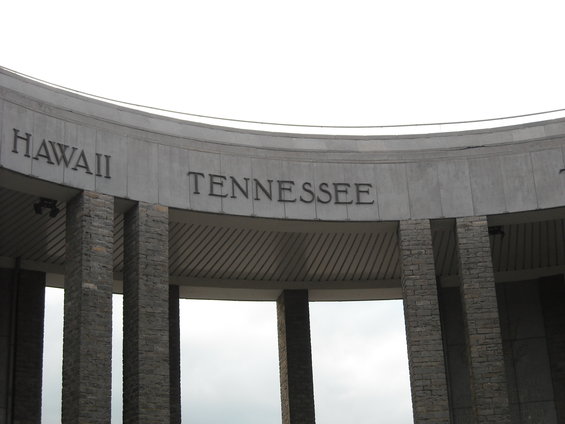 Stone monument with 'HAWAII' and 'TENNESSEE' carved into it, supported by stone pillars
