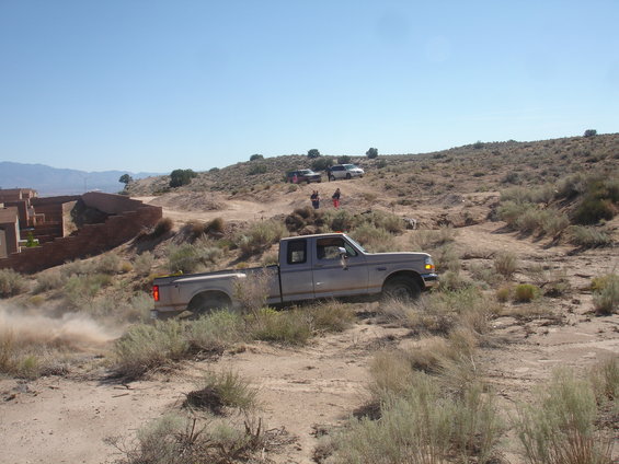 Silver 1992 Ford F-350 driving on dusty off-road terrain