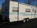 1996 Dodge 2500 - A white travel trailer with blue accents is parked outdoors.