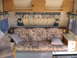 1996 Dodge 2500 - The interior of a recreational vehicle shows a sofa, cabinets, and windows with curtains.