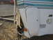 1996 Dodge 2500 - The corner of a recreational vehicle shows significant damage to its exterior paneling and frame.