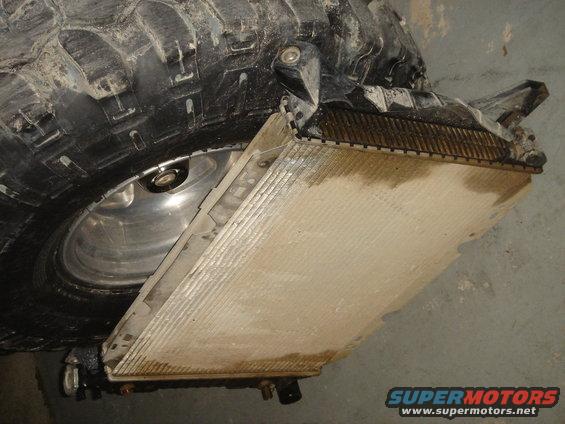 Radiator removed from vehicle, next to large tire