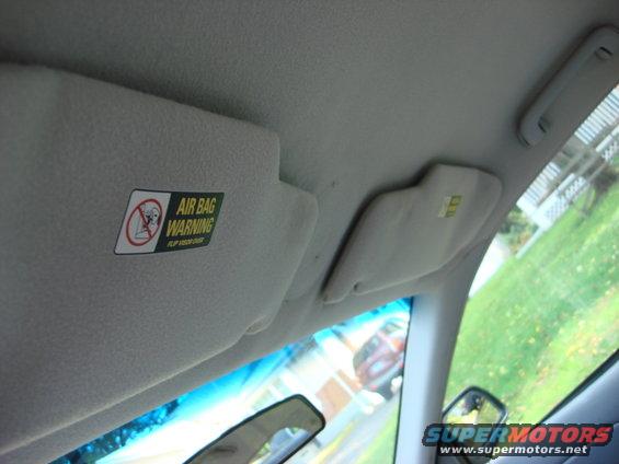 Interior view of a car's sun visor with an air bag warning sticker