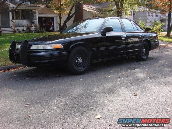 Black 2003 Ford Crown Victoria with a push bumper parked on a street