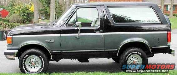 Side view of a black and gray 1989 Ford Bronco parked on grass