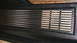1979 Ford Bronco - Close-up of a vehicle's interior door panel, showing a chrome vent and wood grain trim.