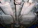 2001 Ford Crown Victoria - The underside of a vehicle shows the dual exhaust system with mufflers and the driveshaft running down the center.