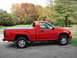 2008 Chevrolet Colorado - A red pickup truck is parked outdoors with trees in the background.
