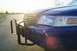 1999 Ford Crown Victoria - Dark blue police car front end with push bar, seen from a low angle at sunset.