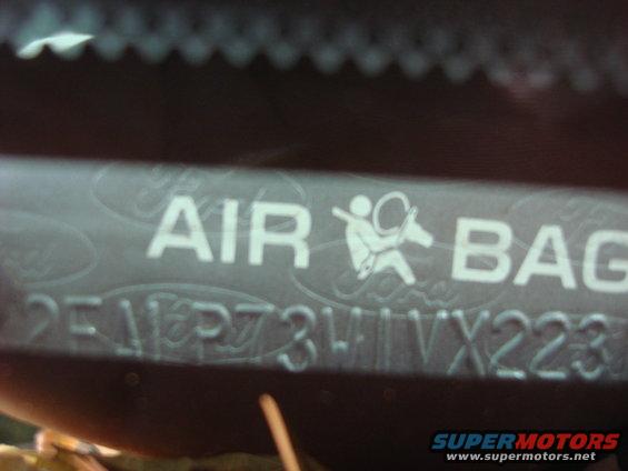 Close-up of an airbag warning label with text and a symbol