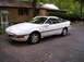 1991 Ford Probe - A white coupe with pop-up headlights and a sunroof is parked on an asphalt driveway.