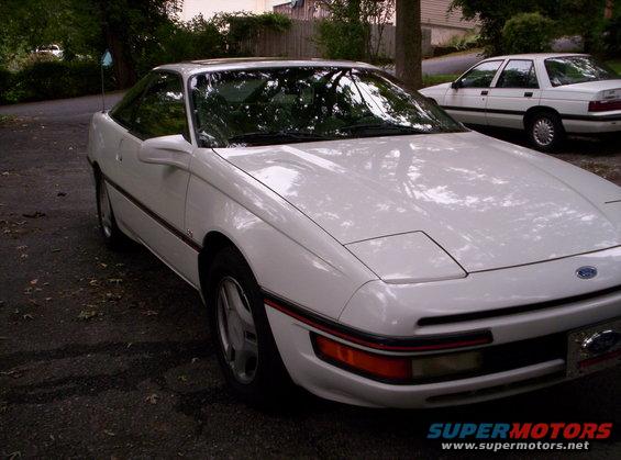 White 1991 Ford Probe coupe with pop-up headlights, front quarter view, parked on asphalt