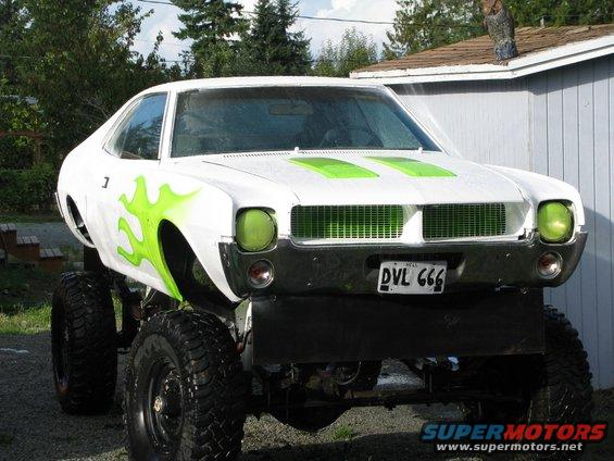 1978 AMC Javelin lifted with large tires and green flame graphics on the side. Green grille and headlights