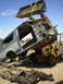 1996 Ford Bronco - A 1996 Ford Bronco body is hoisted by a loader during a teardown process.
