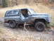 1988 Chevrolet Blazer - A driver is behind the wheel of a modified SUV navigating a wooded trail.
