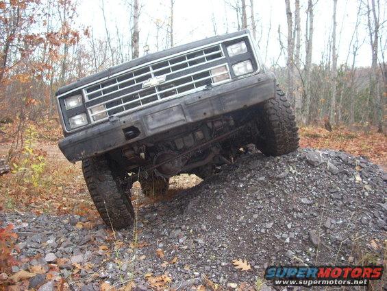 Black 1988 Chevrolet Blazer front grille and tires on rocky incline