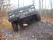 1988 Chevrolet Blazer - A black 1988 Chevrolet Blazer is shown from the front, with its tires climbing a pile of rocks in a wooded area.