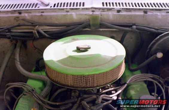 engine bay showing a green air filter housing and various hoses and wires