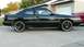 1989 Mazda MX-6 - Side view of a black 1989 Mazda MX-6 GT coupe with aftermarket wheels, parked in front of a garage.