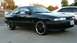1989 Mazda MX-6 - A black coupe with aftermarket wheels is parked in a driveway next to a white car.